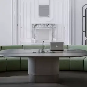 Modernes Konferenzzimmer mit halbrunder grüner Couch, großem Tisch und Laptop für Meetings.
